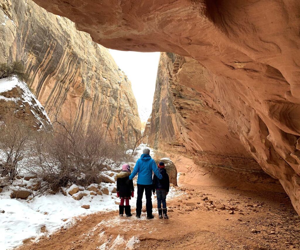 A father with his two children in Capitol Reef National Park, one of the best weekend getaways from Salt Lake City for families.
