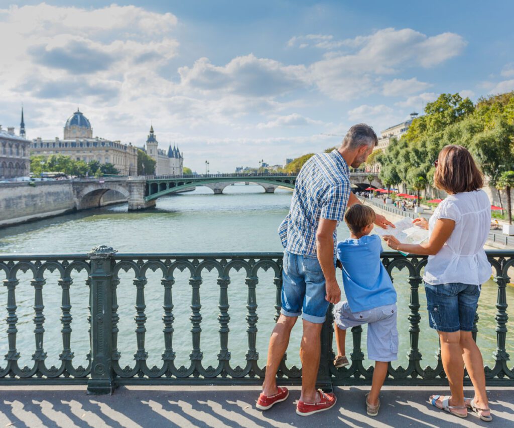 A dad and his two children overlooking the Seine in Paris.