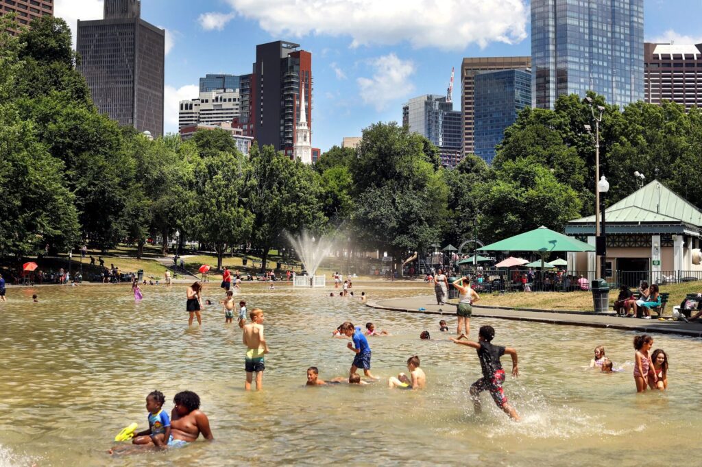 Kids playing in the pond at Boston Common, one of the best places to visit on a Boston itinerary for families in the summer.