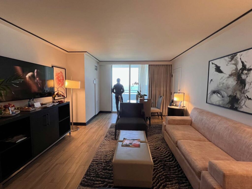 Spacious living room in a Loews Miami Beach Hotel suite with modern decor and a balcony view.