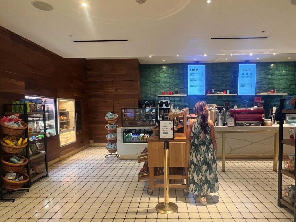 Guest ordering at a cafe in Loews Miami Beach Hotel, with a variety of snacks and drinks on display.